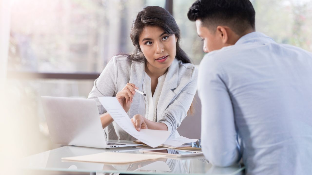 a man and woman discussing a paper