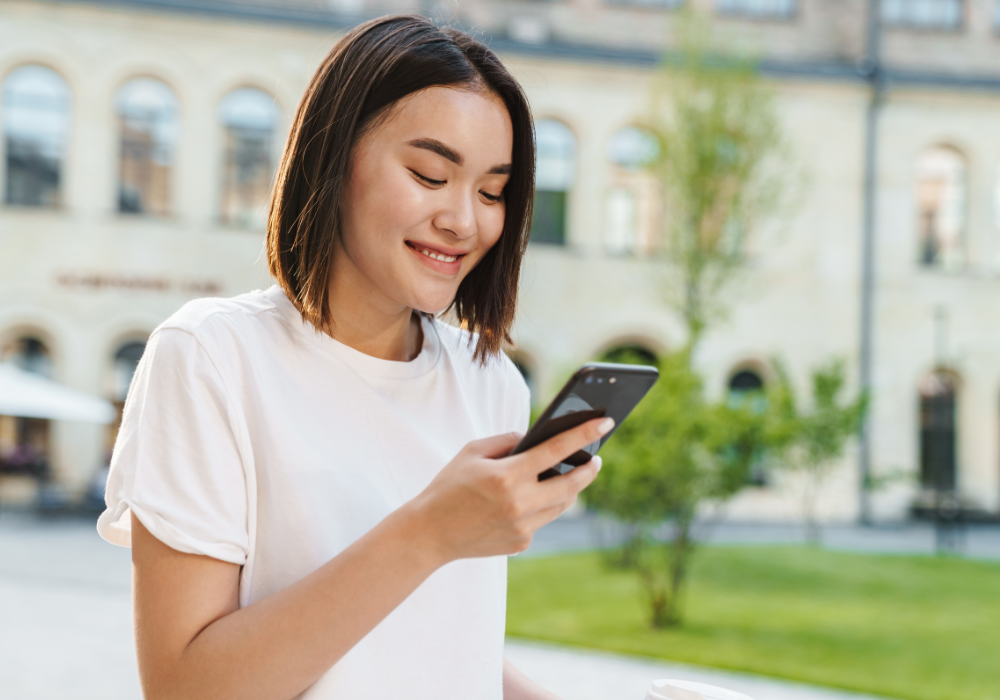 asian female smiling at phone