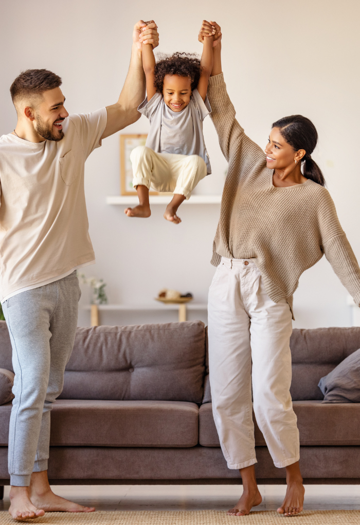 young man and woman holding up their son in the air