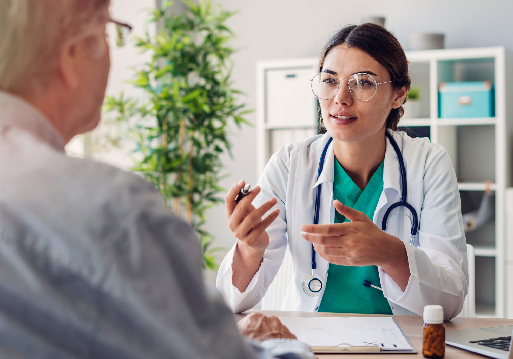 young female doctor speaking with elder male patient