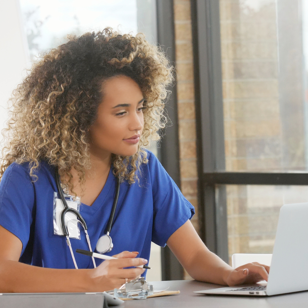 young black nurse looking at computer screen