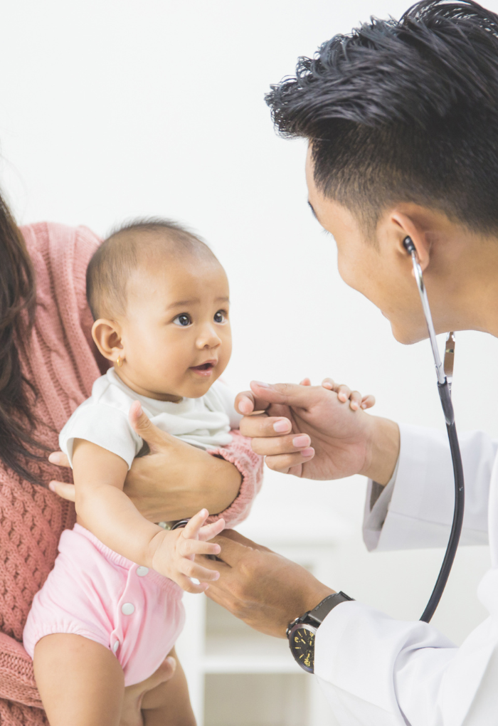 asian baby looking up at a male doctor