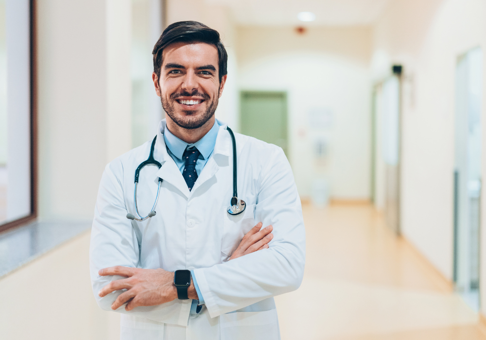 smiling male doctor with arms crossed