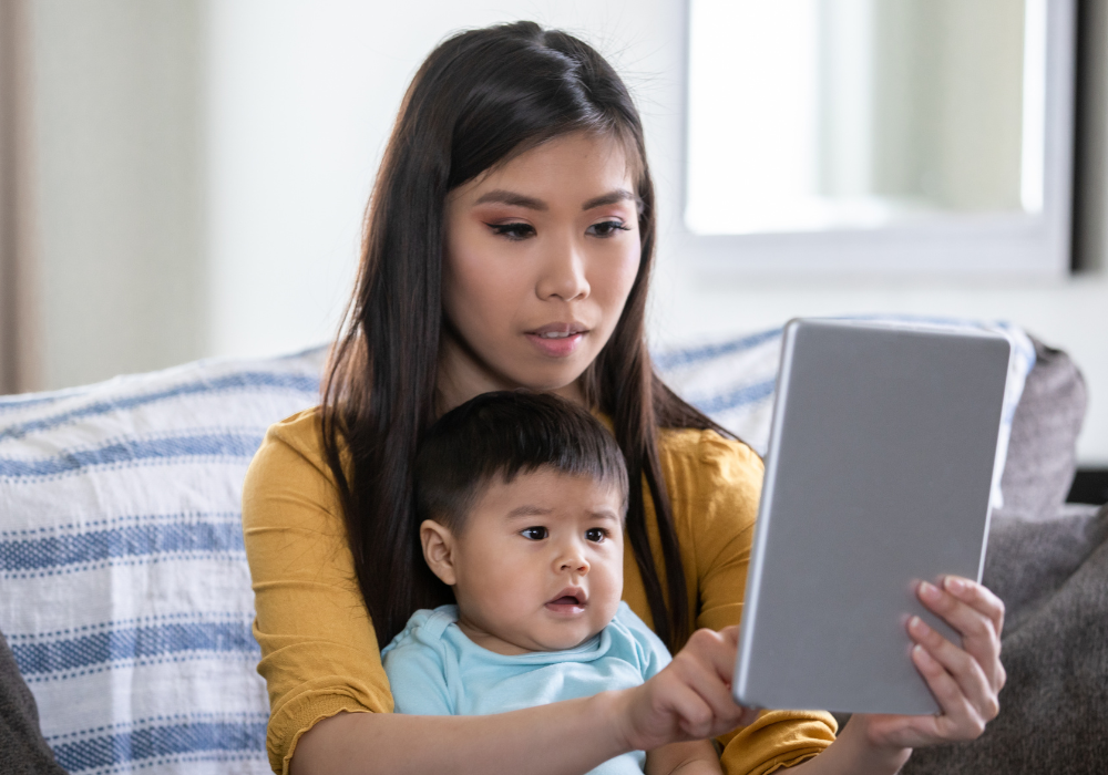 young woman with baby looking at a tablet